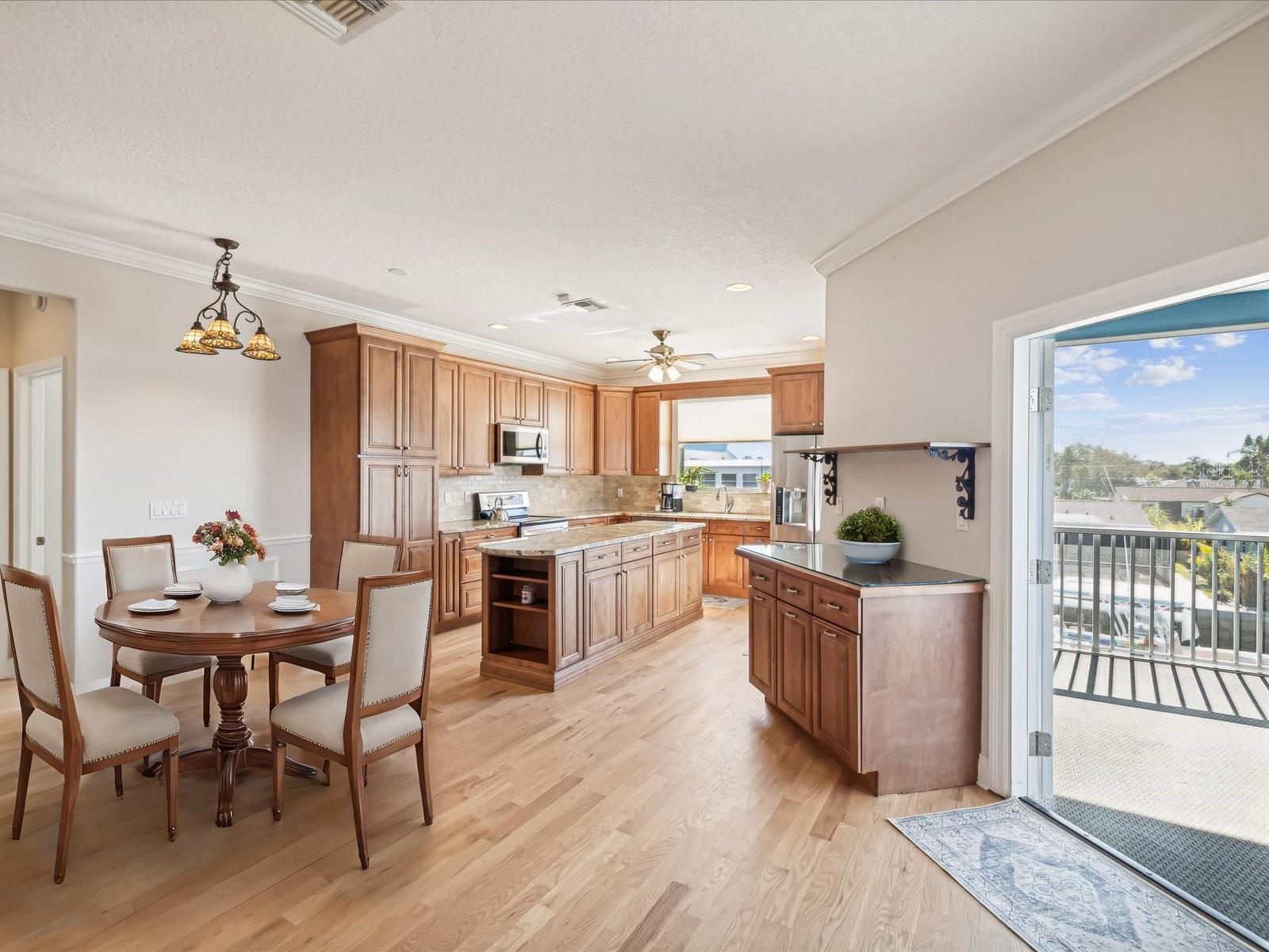 Dining Room (table virtually staged) and Kitchen, each with French doors to the screened Balcony.