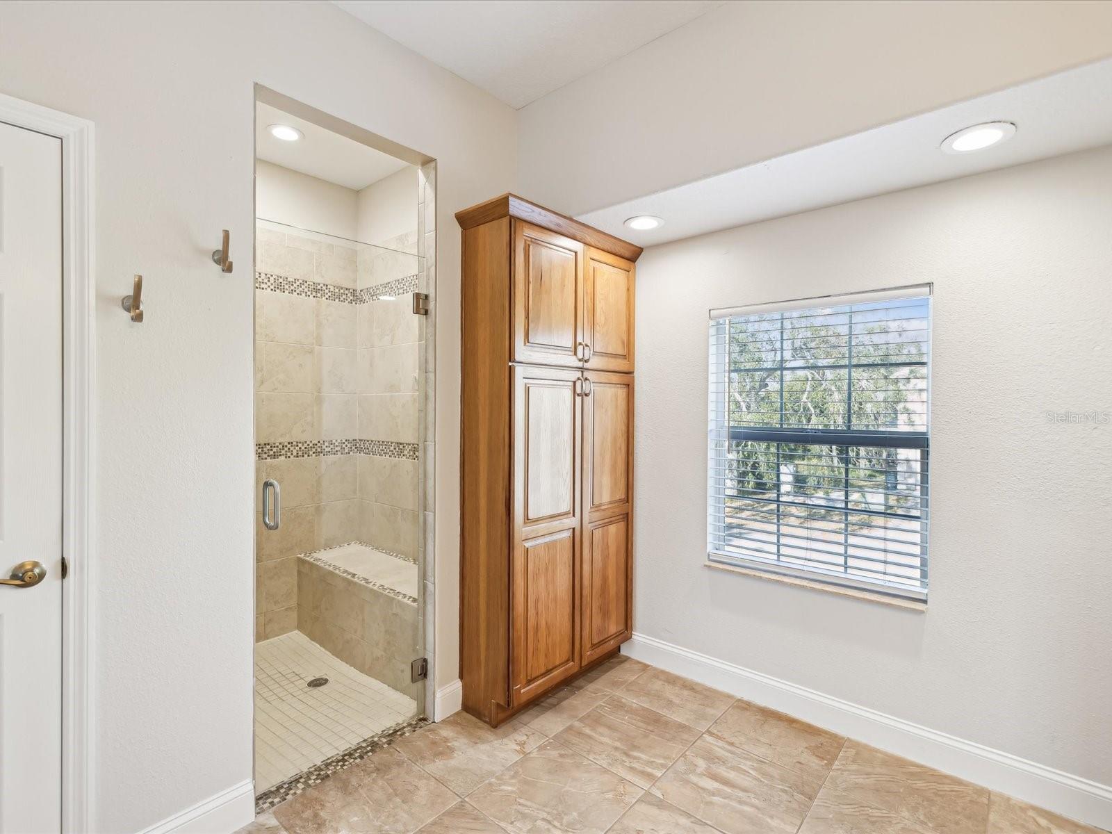 Primary Bath, extra cabinets, linen closet and accessible roll in shower.