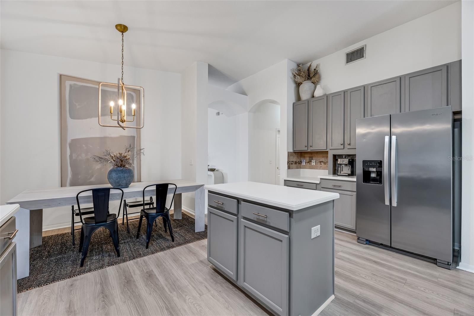 The kitchen flows into an eat-in area that accommodates a large table under a stylish light fixture.