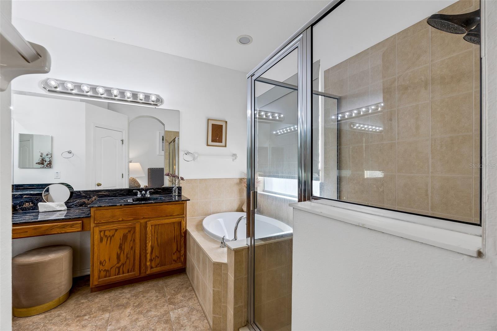 The primary ensuite features a soaking tub, walk-in shower, dual vanities, and a water closet.