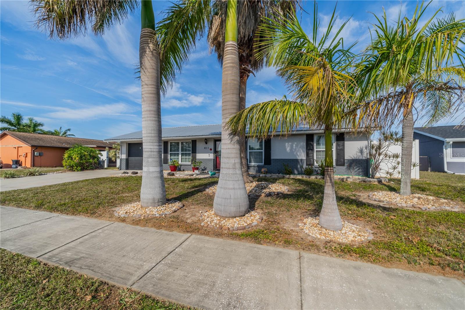 BEAUTIFUL PALMS ENHANCE THE FRONT YARD