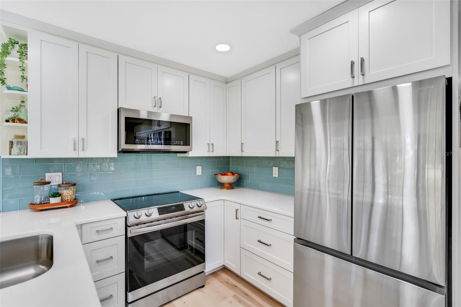 Gorgeous kitchen remodel with solid wood cabinetry, quartz counters, & Crystal Skies glass splash wall~