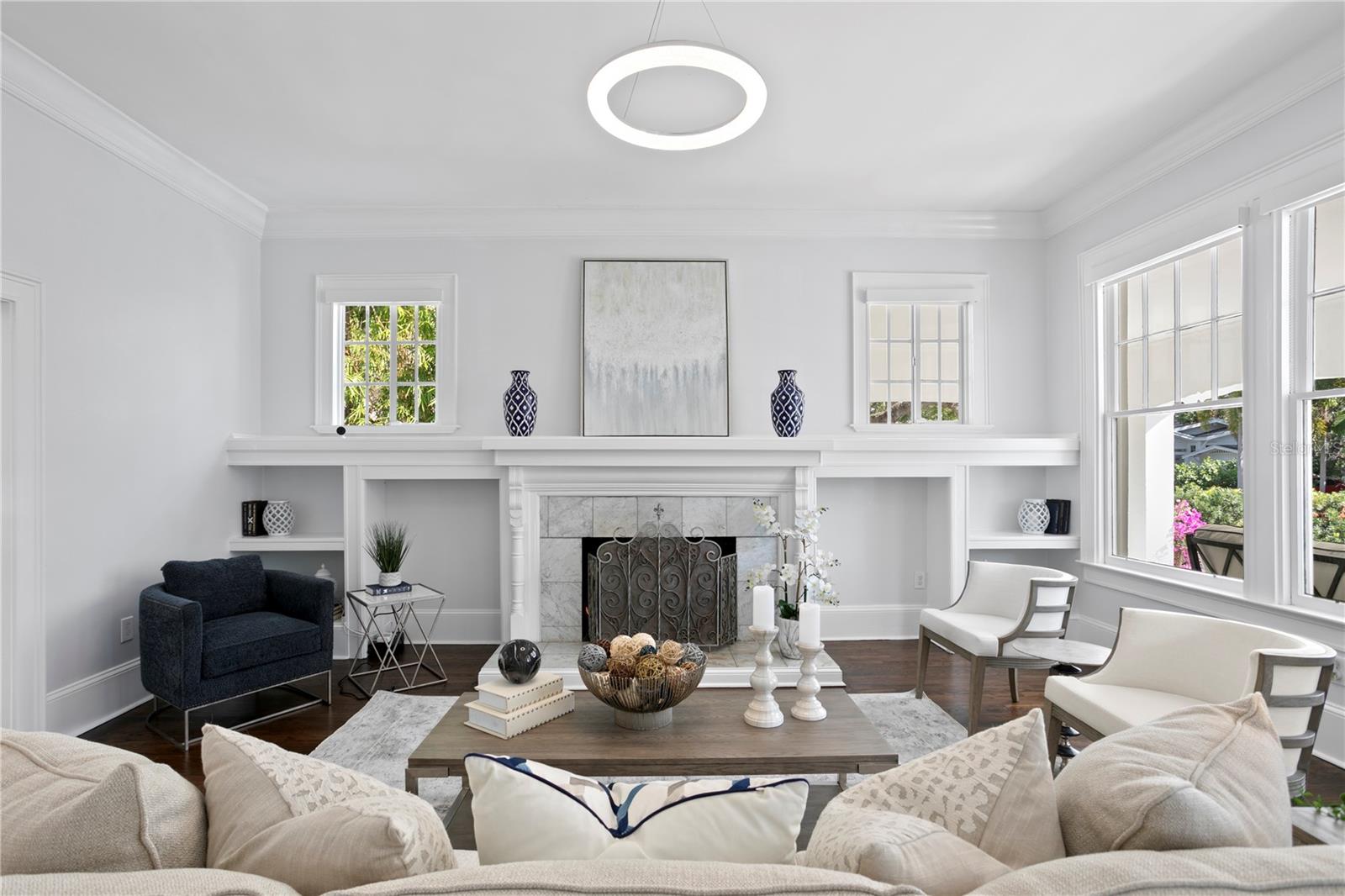 Step inside the home into the formal living room with fireplace with marble surround, flanked by built ins and loads of windows allowing beautiful natural light to fill the space.