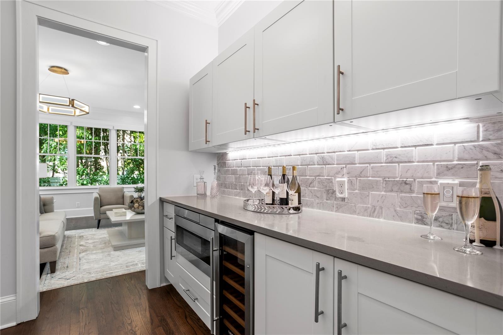 This wet bar area is an extension of the kitchen and leads into the back of the home with a family room.