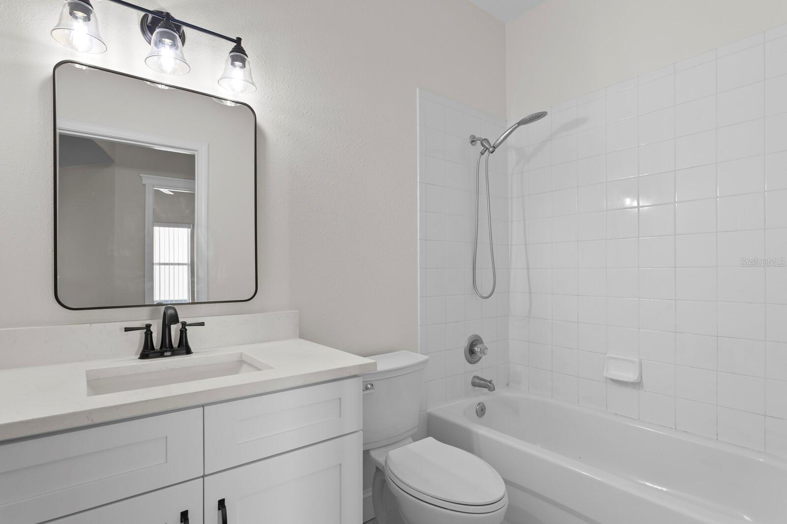 The 2nd full bath has been updated to include a new vanity, quartz counters, fixtures & lighting