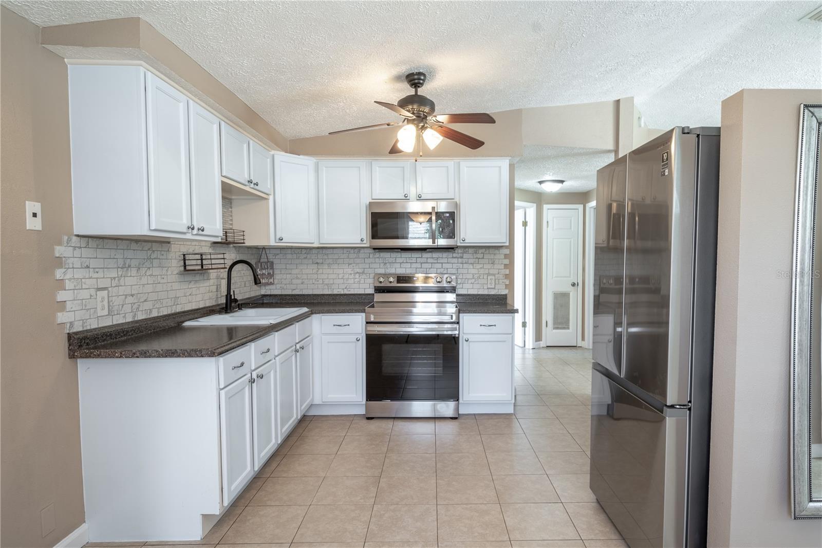 Granite countertop and subway tile backsplash accentuate the stylish cabinetry.