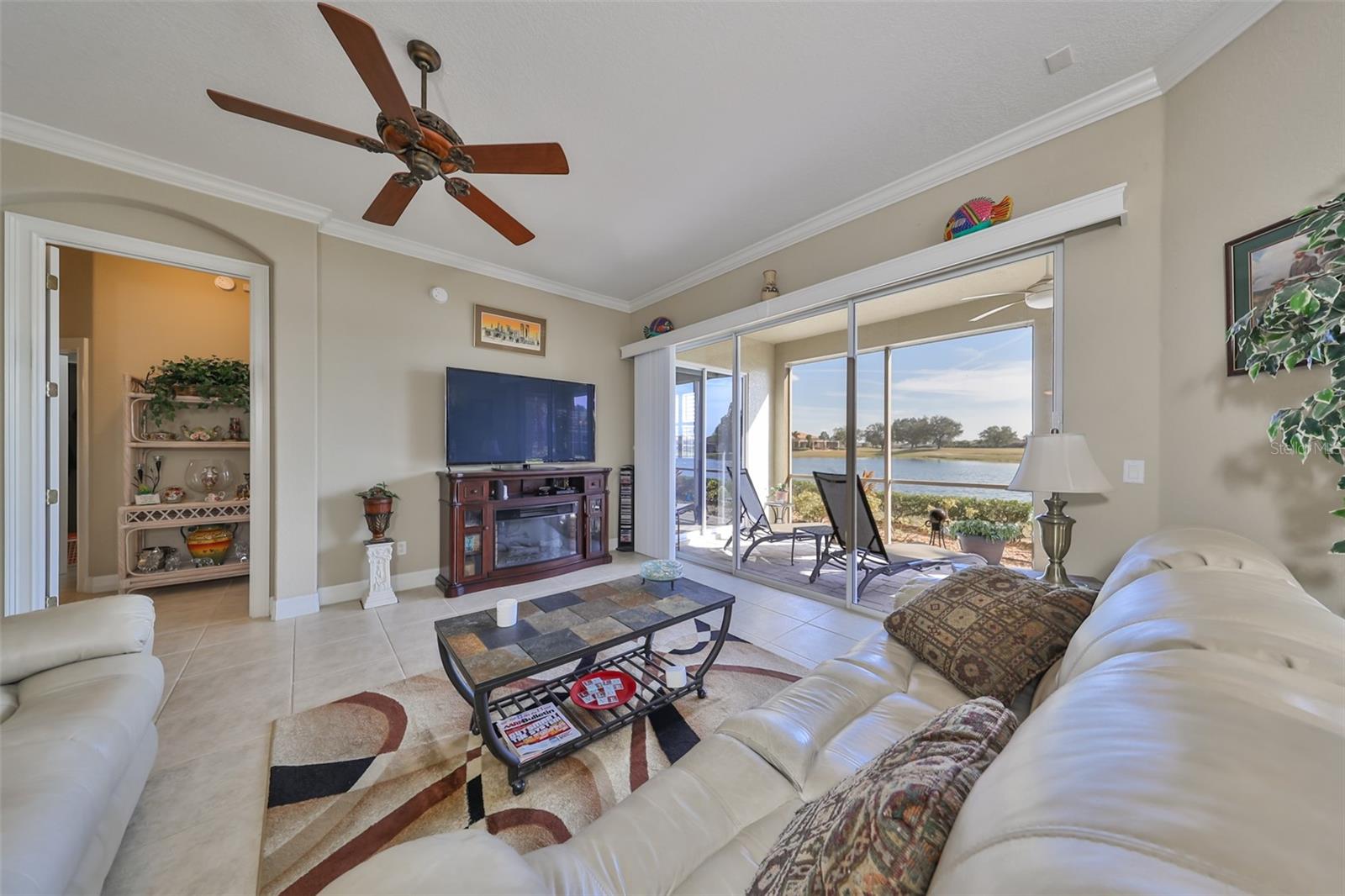 The great room is large with water views and a custom ceiling fan.  Notice the 10-12' ceiling and crown molding.