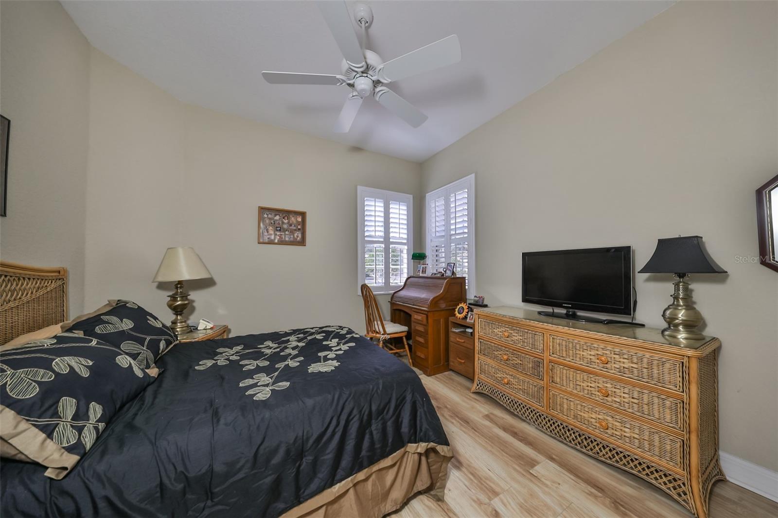 Bedroom #2 has engineered wood flooring, corner windows and plantation shutters.