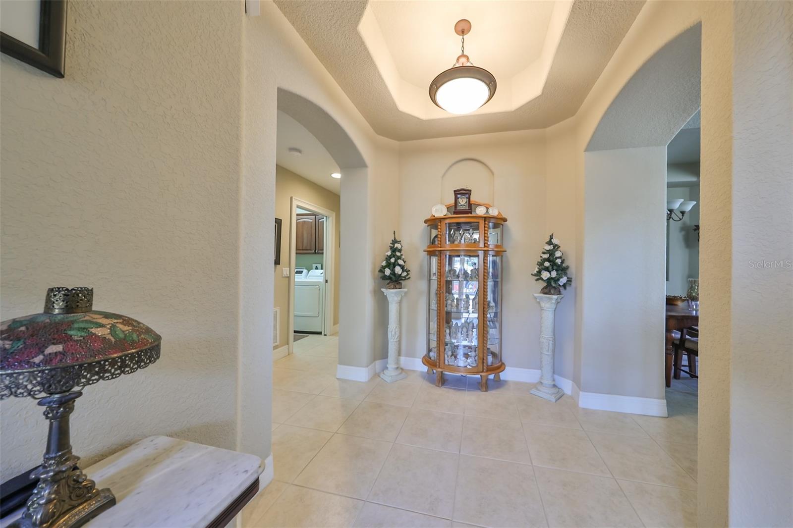 Notice the trey ceiling, architectural niche and custom lighting in the front foyer.