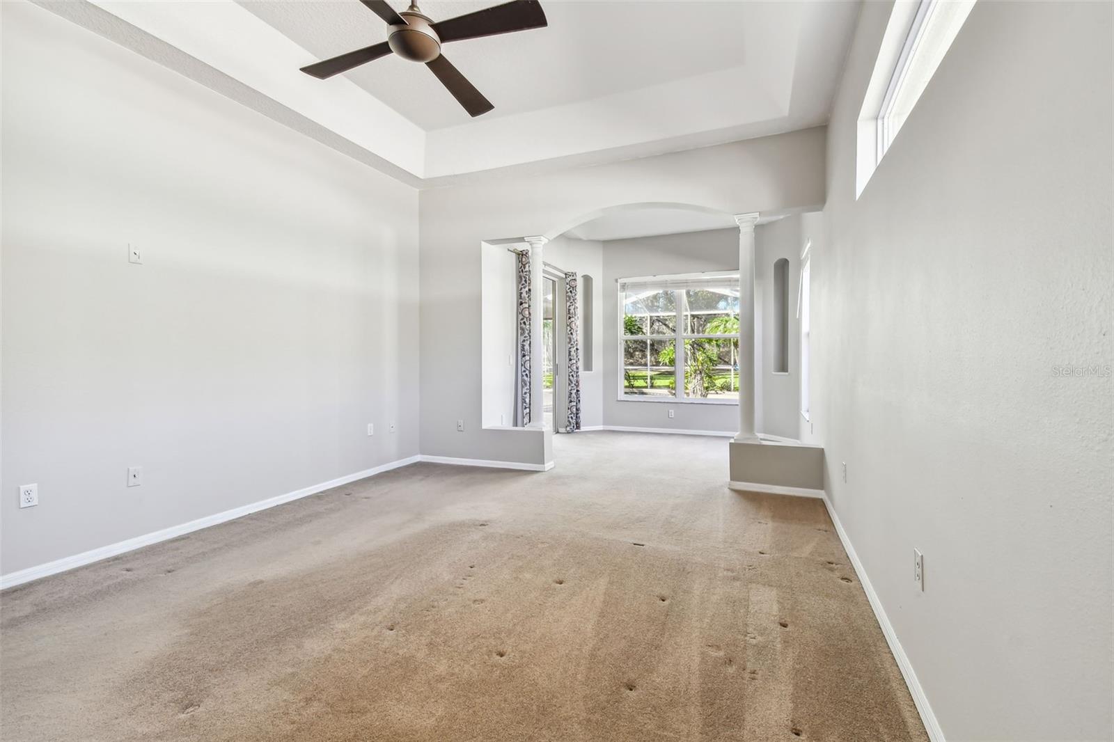 Primary bedroom is adorned with tray ceilings.