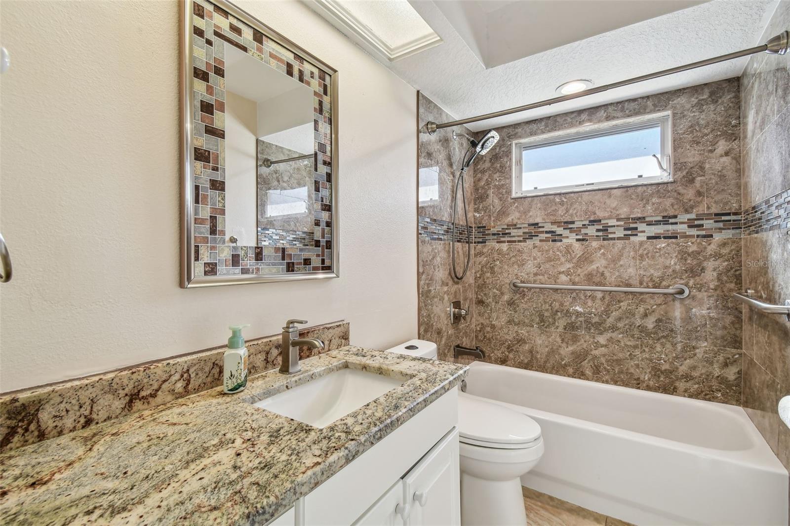 Bathroom 2 has stone countertops with a shower/tub combo.