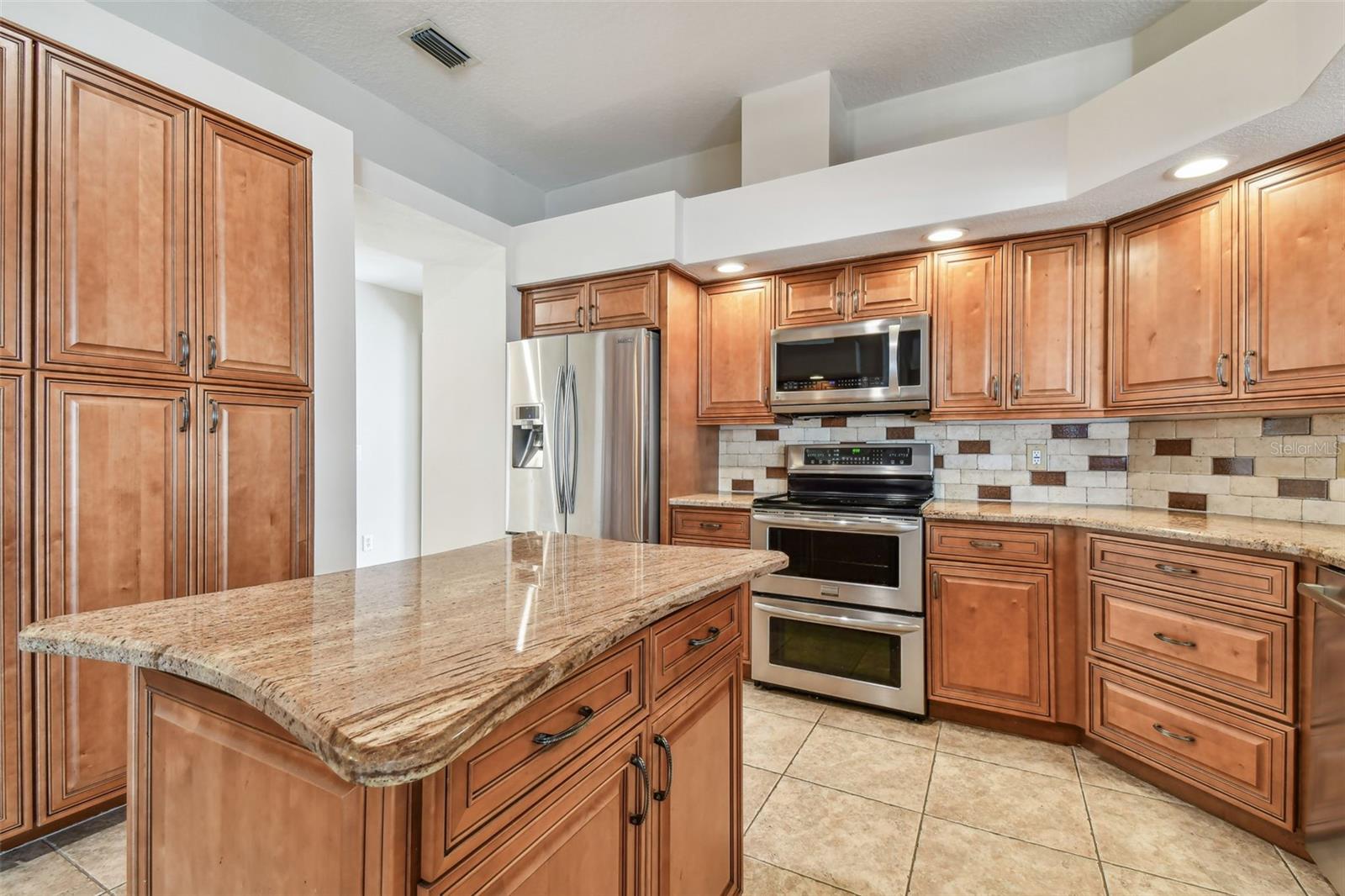 Stainless steel appliances and backsplash really make this kitchen POP!