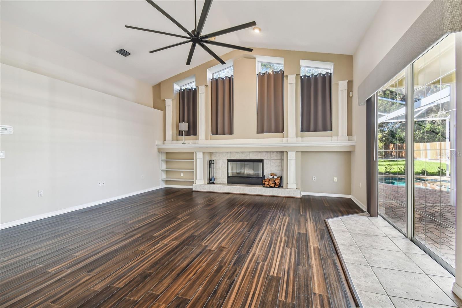 This family room is quite spacious and includes a wood burning fireplace.