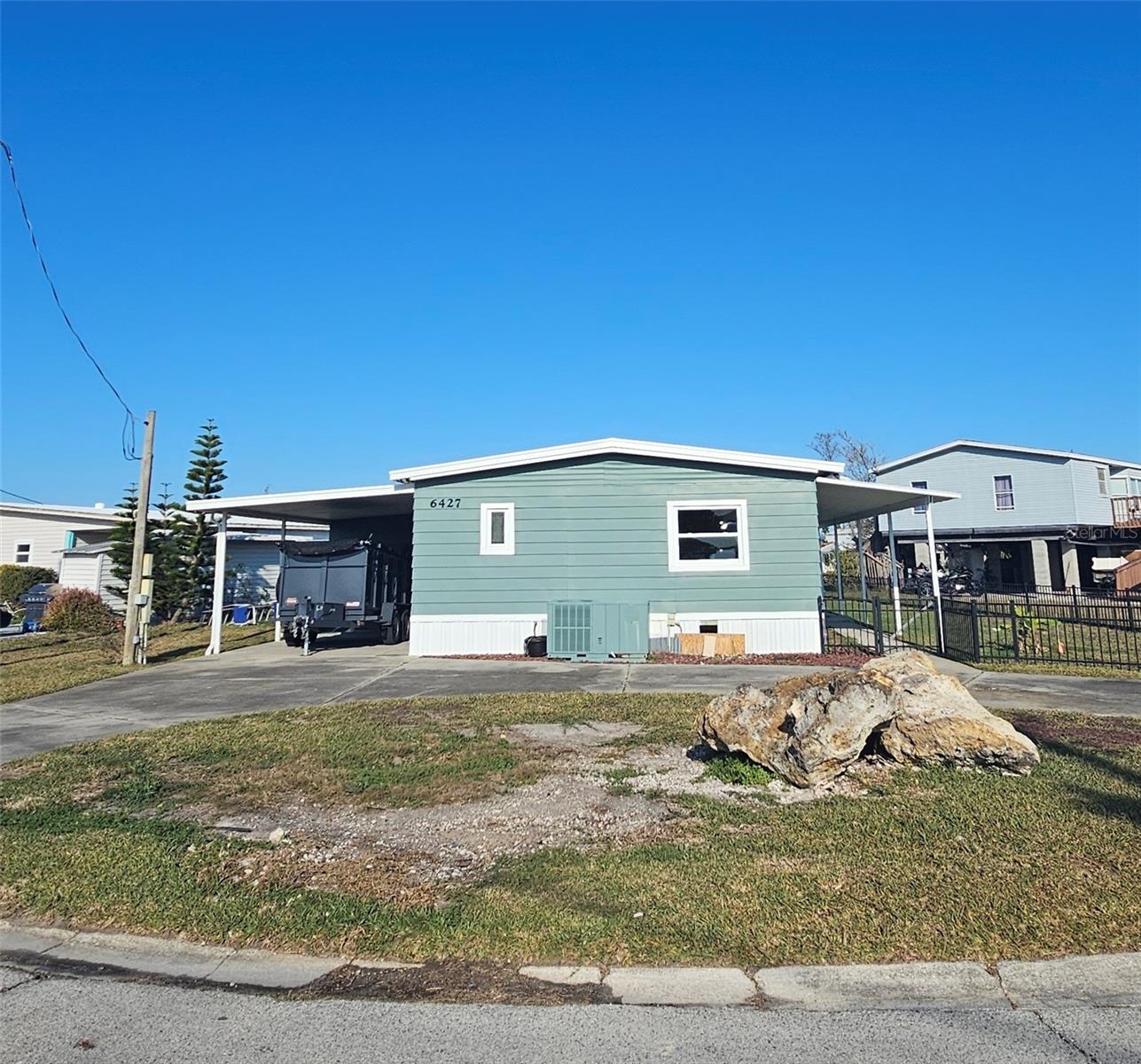 Front view of 6427 TOWER DR! Has a U shaped driveway for easy access in & out! Located on a courner lot so LOT's of yard  which is also fenced in for kids & pets. Includes a boat lift, lots of open concept living space inside. Large covered porch on the canal side. A great home for entertaining!