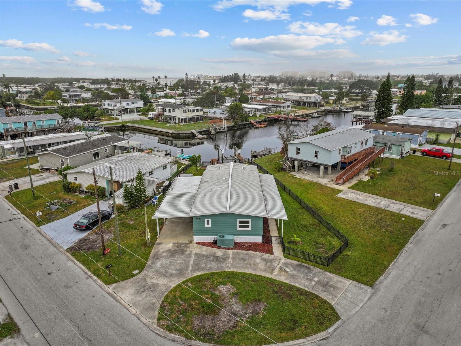 Front view of 6427 TOWER DR! Has a U shaped driveway for easy access in & out! Located on a courner lot so LOT's of yard  which is also fenced in for kids & pets. Includes a boat lift, lots of open concept living space inside. Large covered porch on the canal side. A great home for entertaining!