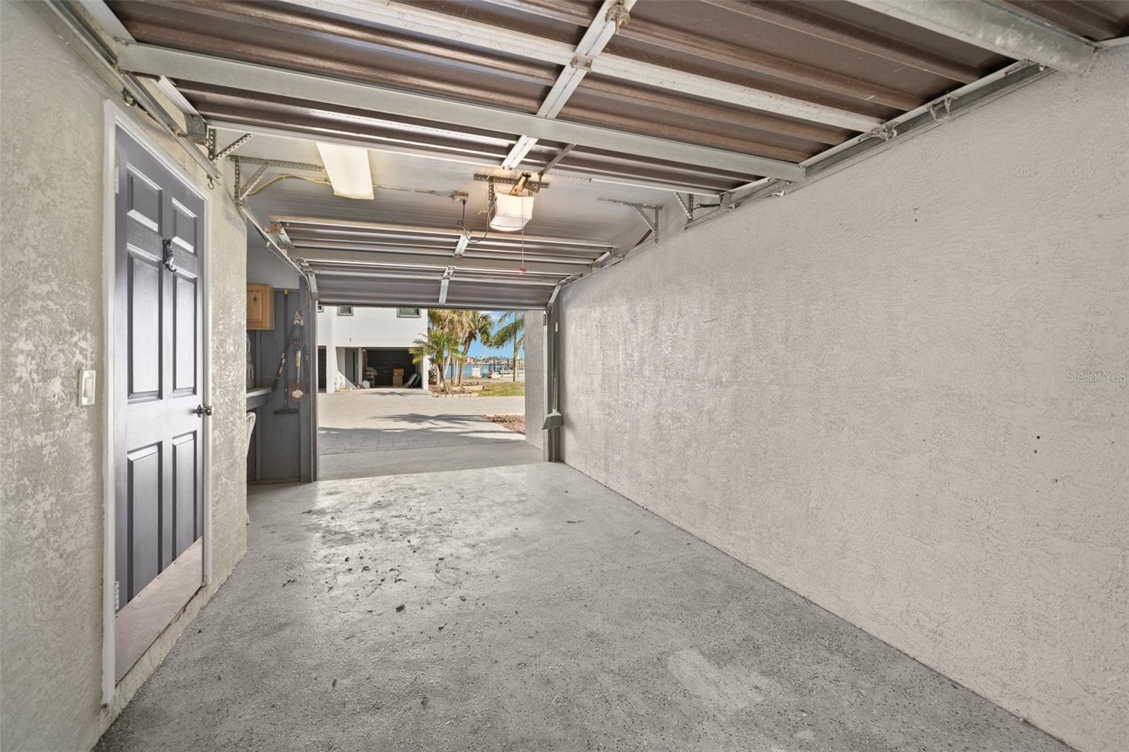 Pass-through garage with two garage doors. Also, a storage room and a workbench.