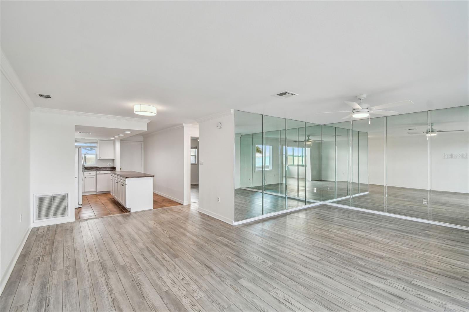 looking into living room with beautiful water reflections off mirrors, dining room and Kitchen