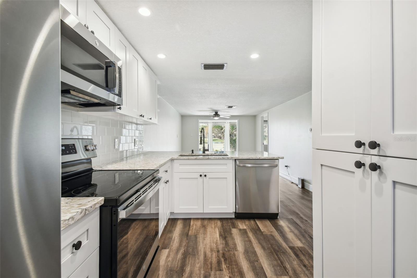 NEW LUXURY VINYL PLANK FLOORING THROUGHOUT, NEW KITCHEN WITH MODERN CABINETRY+HARDWARE, QUARTZ COUNTERTOPS, SS APPLIANCES, ADDITIONAL DRY GOODS PANTRY, LED LIGHTING, NEW HVAC, FRESHLY PAINTED INTERIOR.