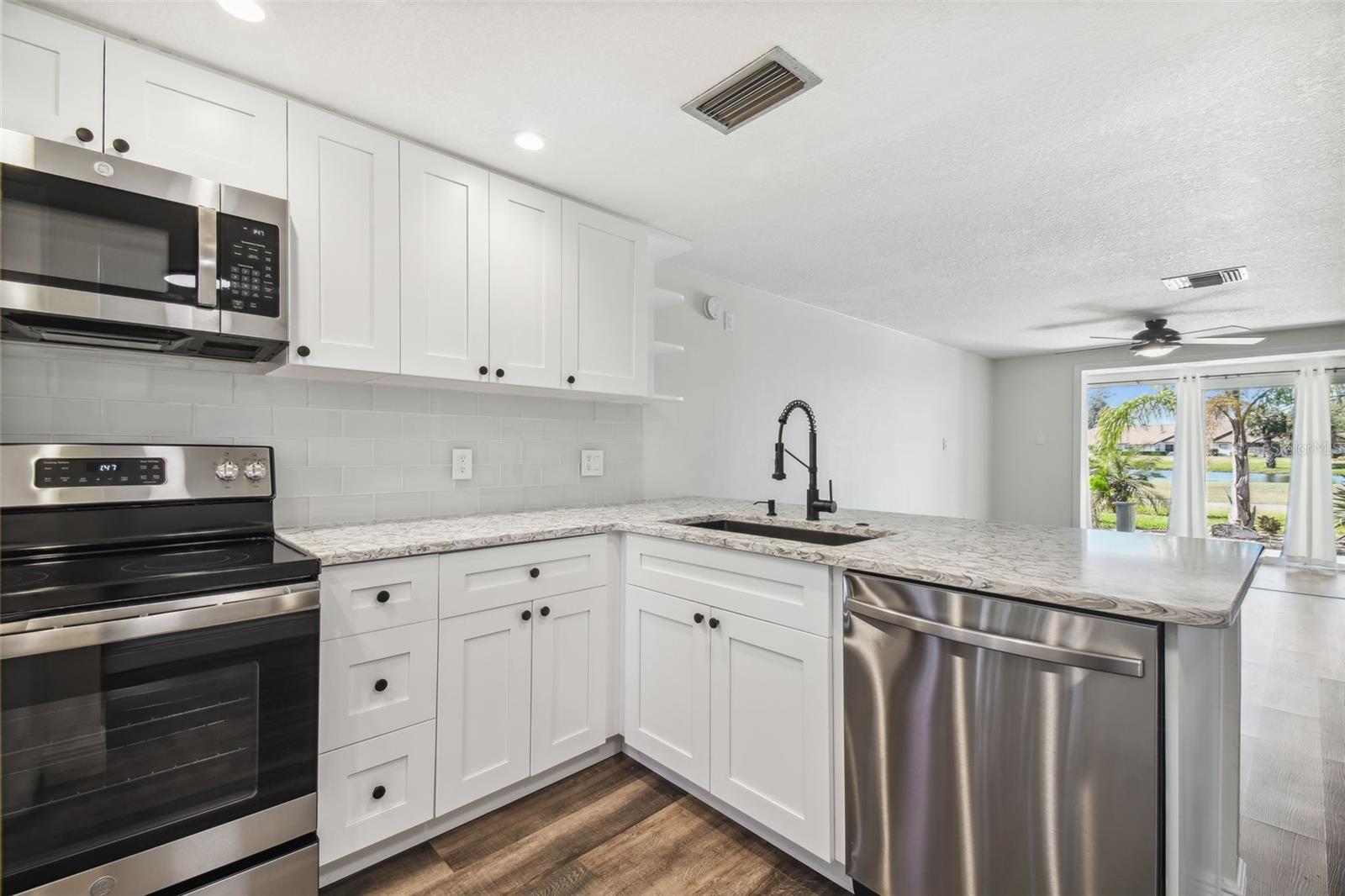 NEW LUXURY VINYL PLANK FLOORING THROUGHOUT, NEW KITCHEN WITH MODERN CABINETRY+HARDWARE, QUARTZ COUNTERTOPS, SS APPLIANCES, ADDITIONAL DRY GOODS PANTRY, LED LIGHTING, NEW HVAC, FRESHLY PAINTED INTERIOR.