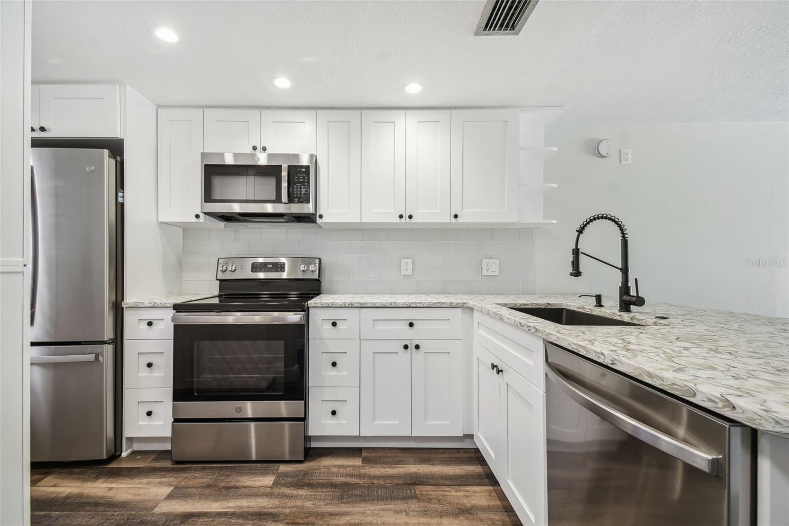 NEW LUXURY VINYL PLANK FLOORING THROUGHOUT, NEW KITCHEN WITH MODERN CABINETRY+HARDWARE, QUARTZ COUNTERTOPS, SS APPLIANCES, ADDITIONAL DRY GOODS PANTRY, LED LIGHTING, NEW HVAC, FRESHLY PAINTED INTERIOR.