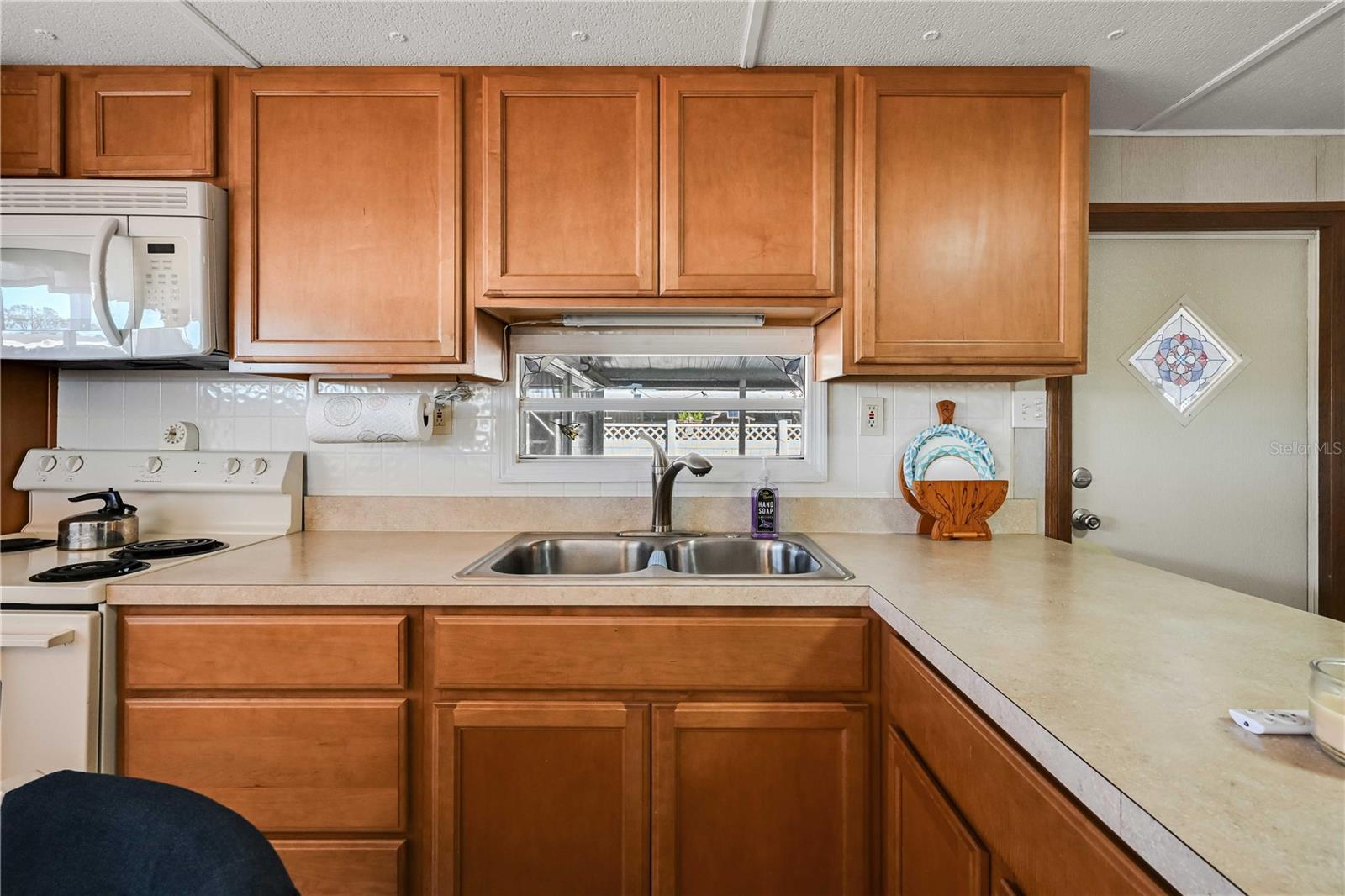 Kitchen has real wood cabinets, updated counter tops, and vinyl flooring.