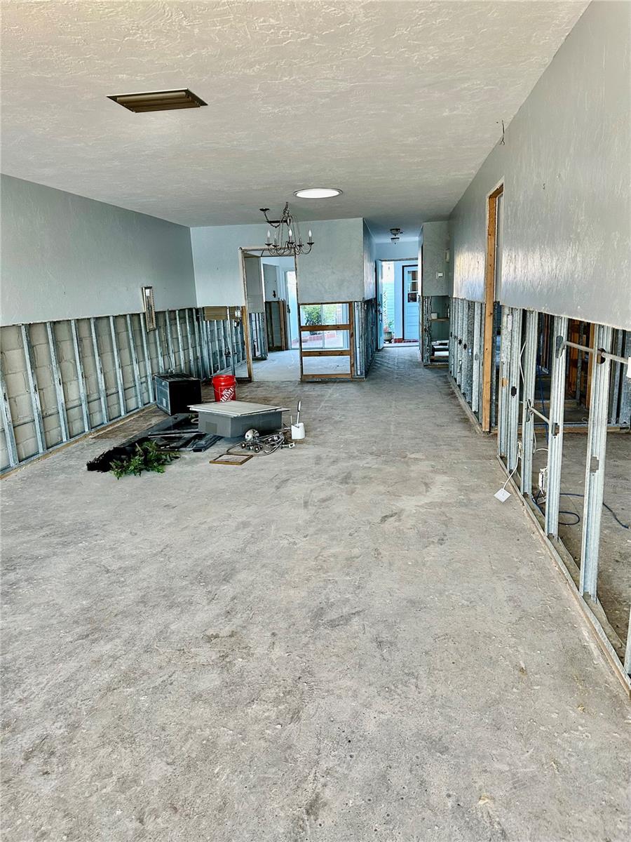 Living area looking towards Dining, front door and kitchen.