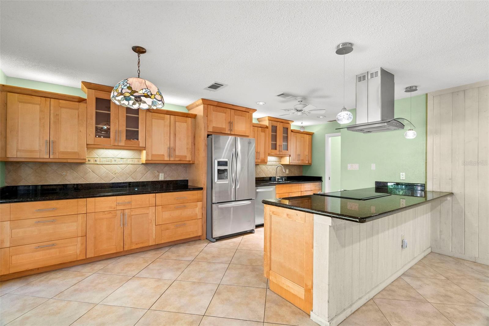 A well-equipped kitchen which features honey-toned wood cabinetry.