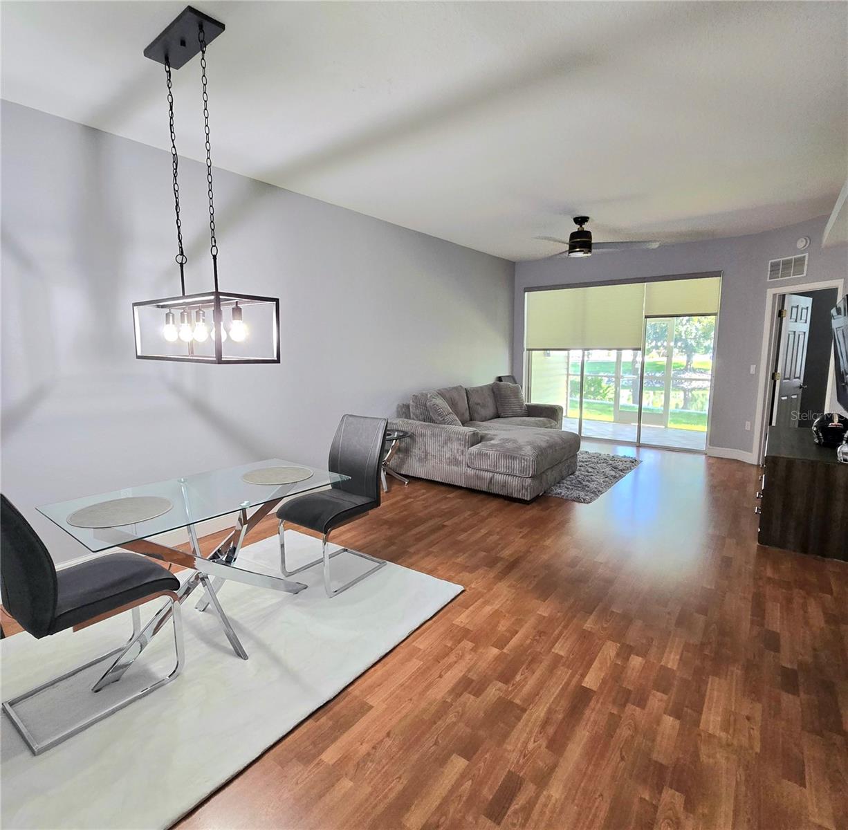 Living room with custom motorized blinds leading out to patio and pon views