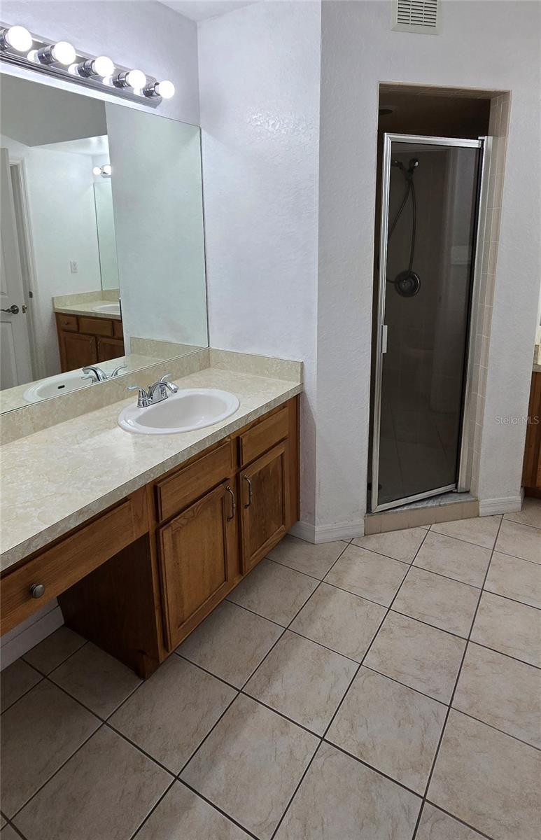 Large master bath with sinks on each side of walk-in shower