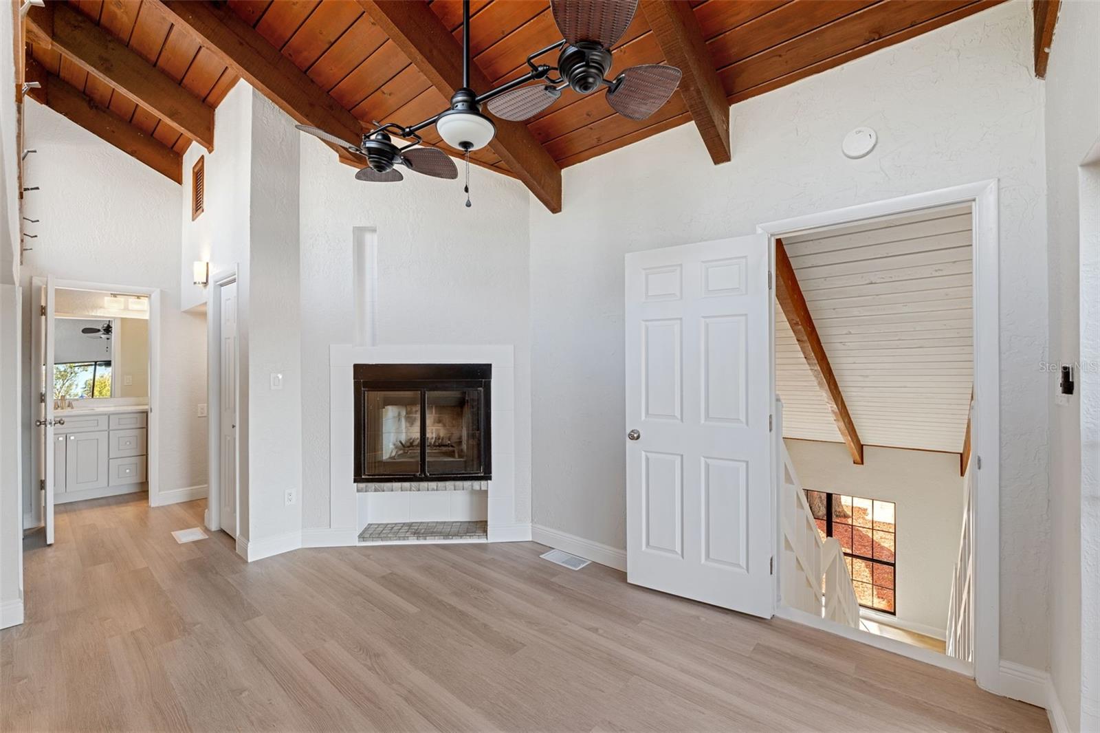 Upstairs master bedroom with a fireplace, very high vaulted ceilings and transient windows for lots of natural light.