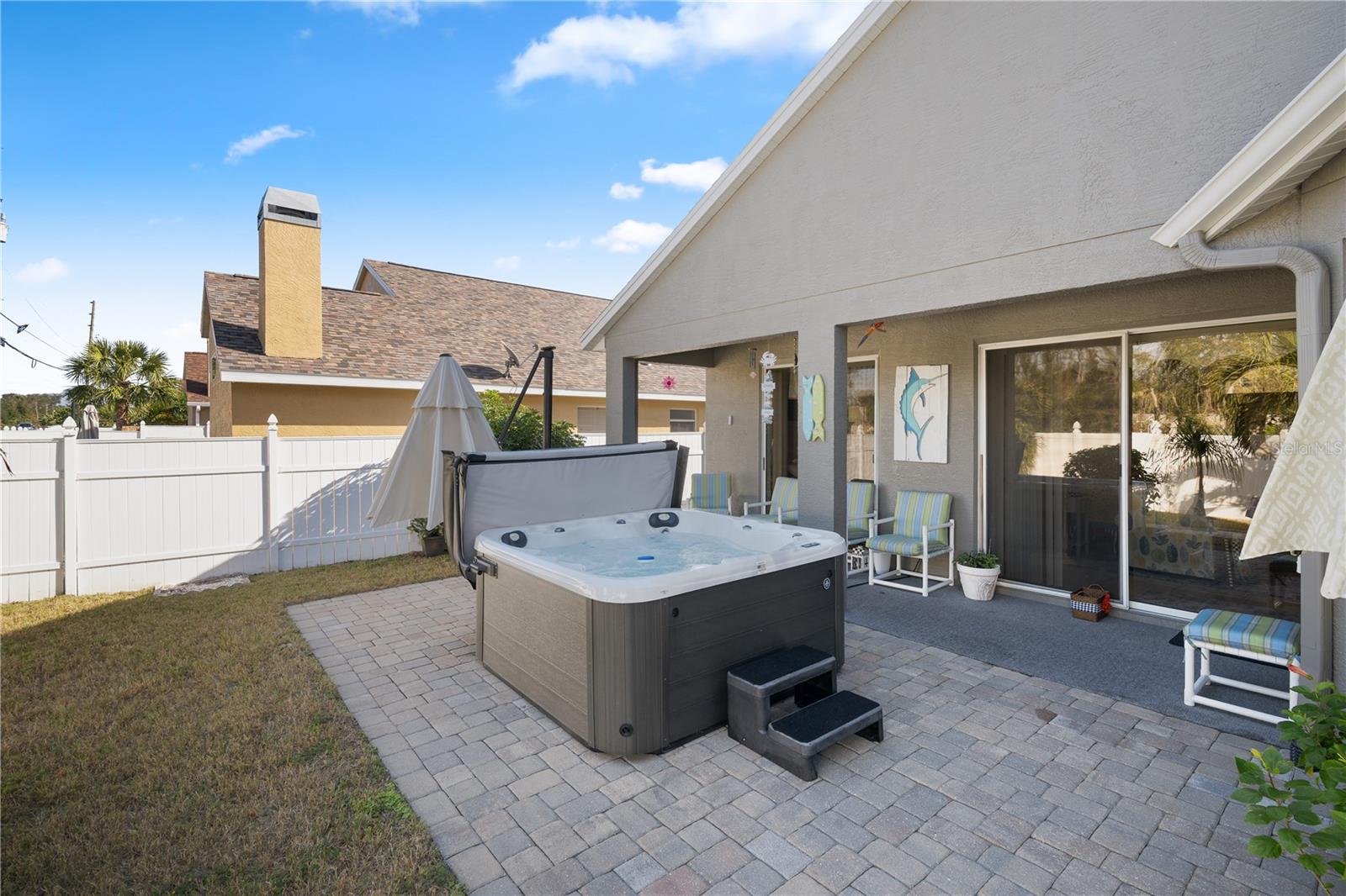 Fully fenced backyard featuring a brand-new 6-person hot tub.