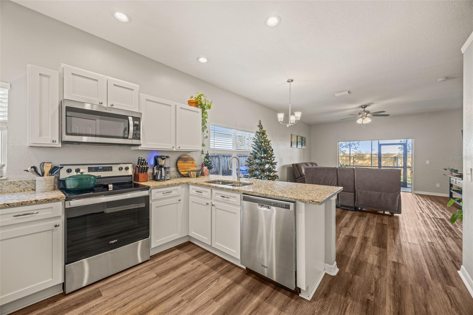 Spacious kitchen with recessed lighting and stainless steel appliances.