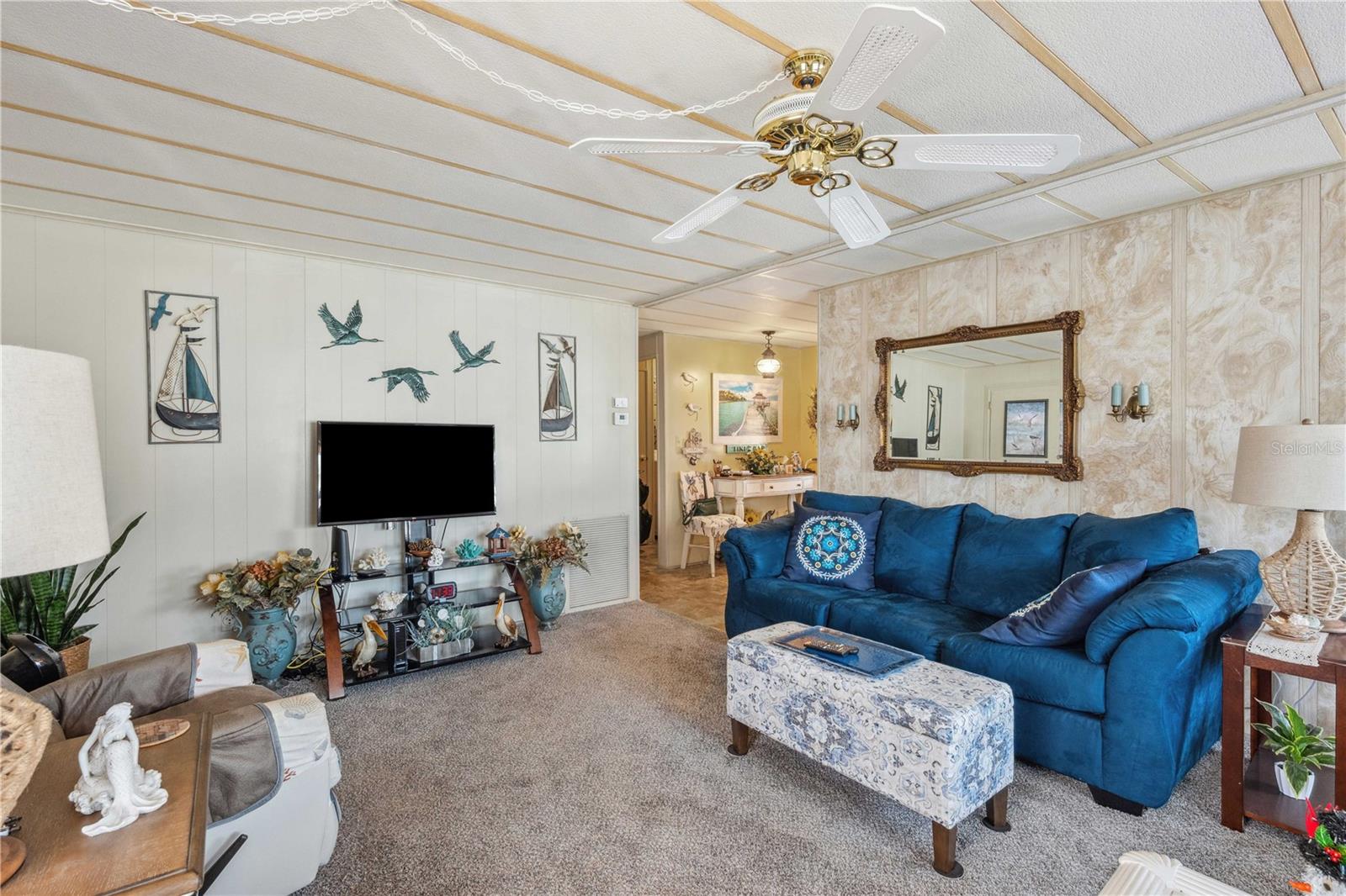 Living room has Berber carpeting, ceiling fan, so much more!