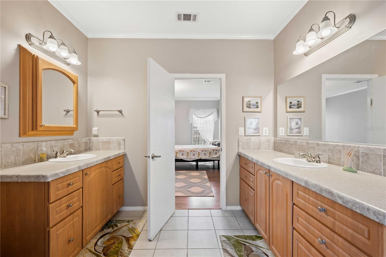 Primary retreat has split vanity, step-in shower, and tub with tile flooring.