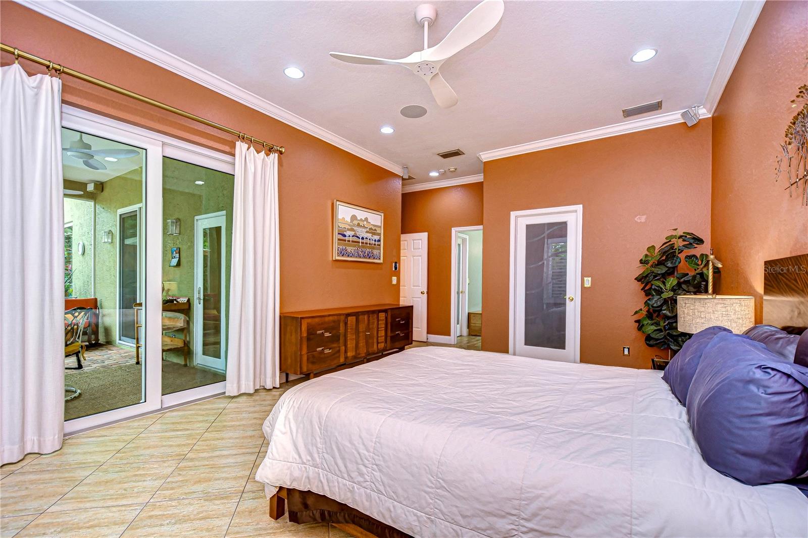 Primary bedroom is so spacious and features sliders leading out to the pool!