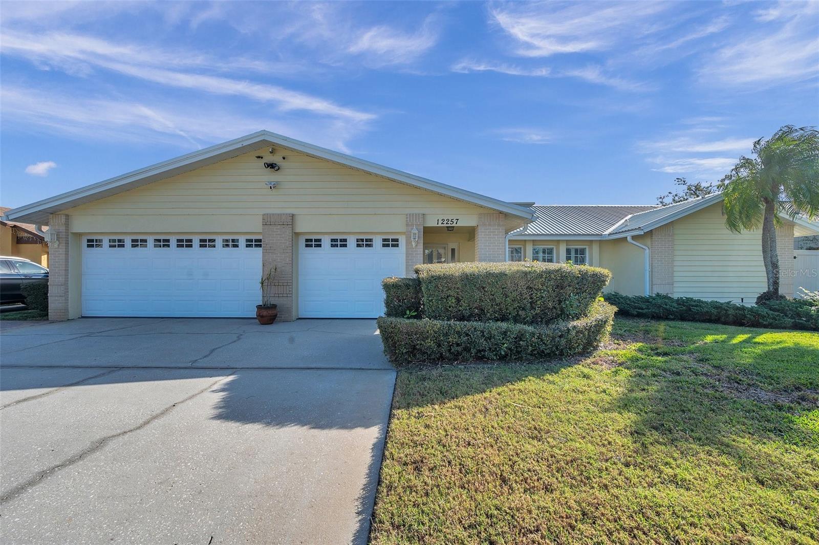 3 car garage with oversized parking pad.  Camera's top of garage pool area and front door. Rain gutters in front. Back yard has French drains for efficiency. Commercial grade insulated standing seam roof.