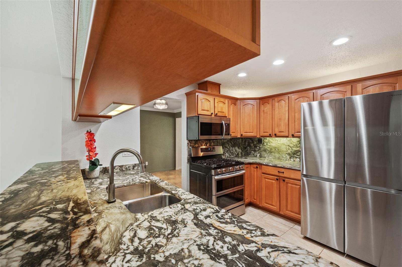 Kitchen with granite counters Maple cabinets, Samsung appliances, vented microwave and gas range with dual oven.   Voice IQ Delta Faucet.