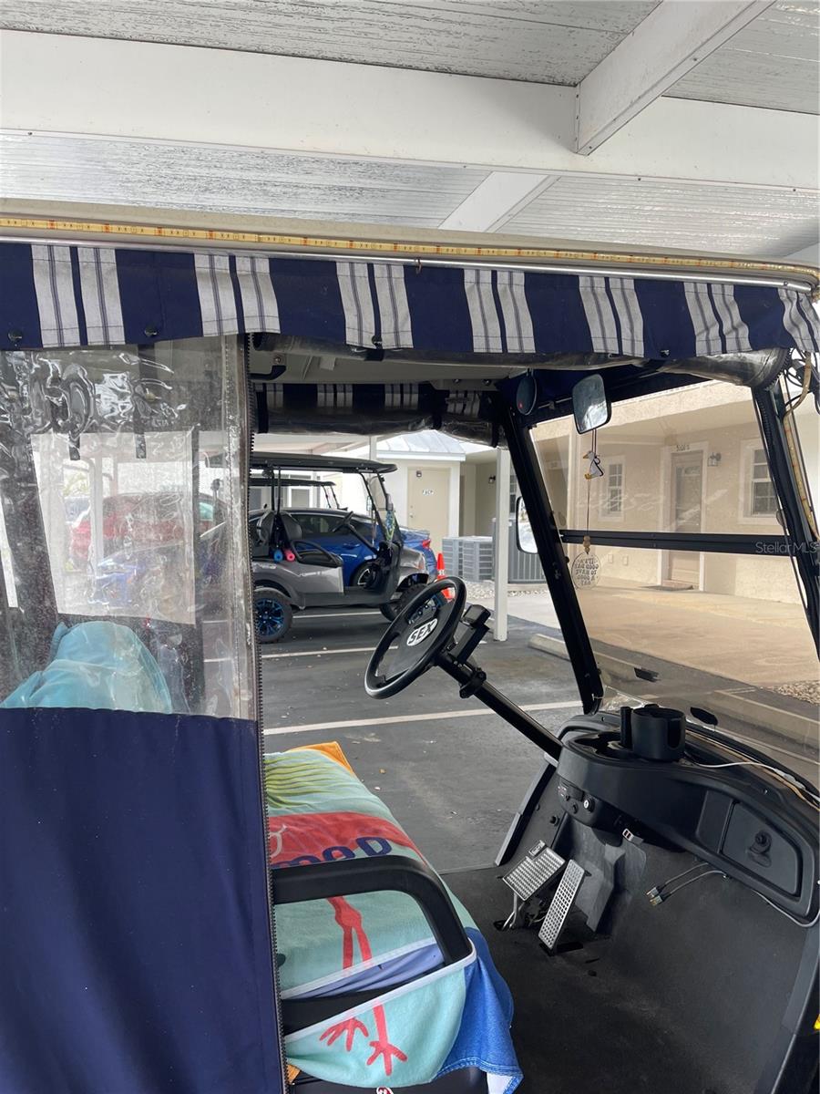 Golf cart has rain cover.