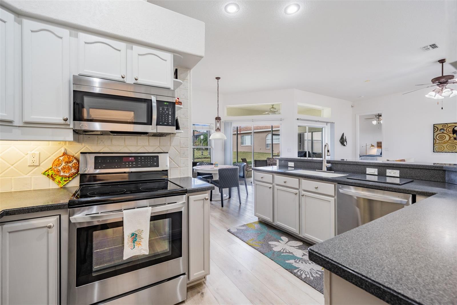 Stainless appliances and custom painted cabinets in this OPEN kitchen