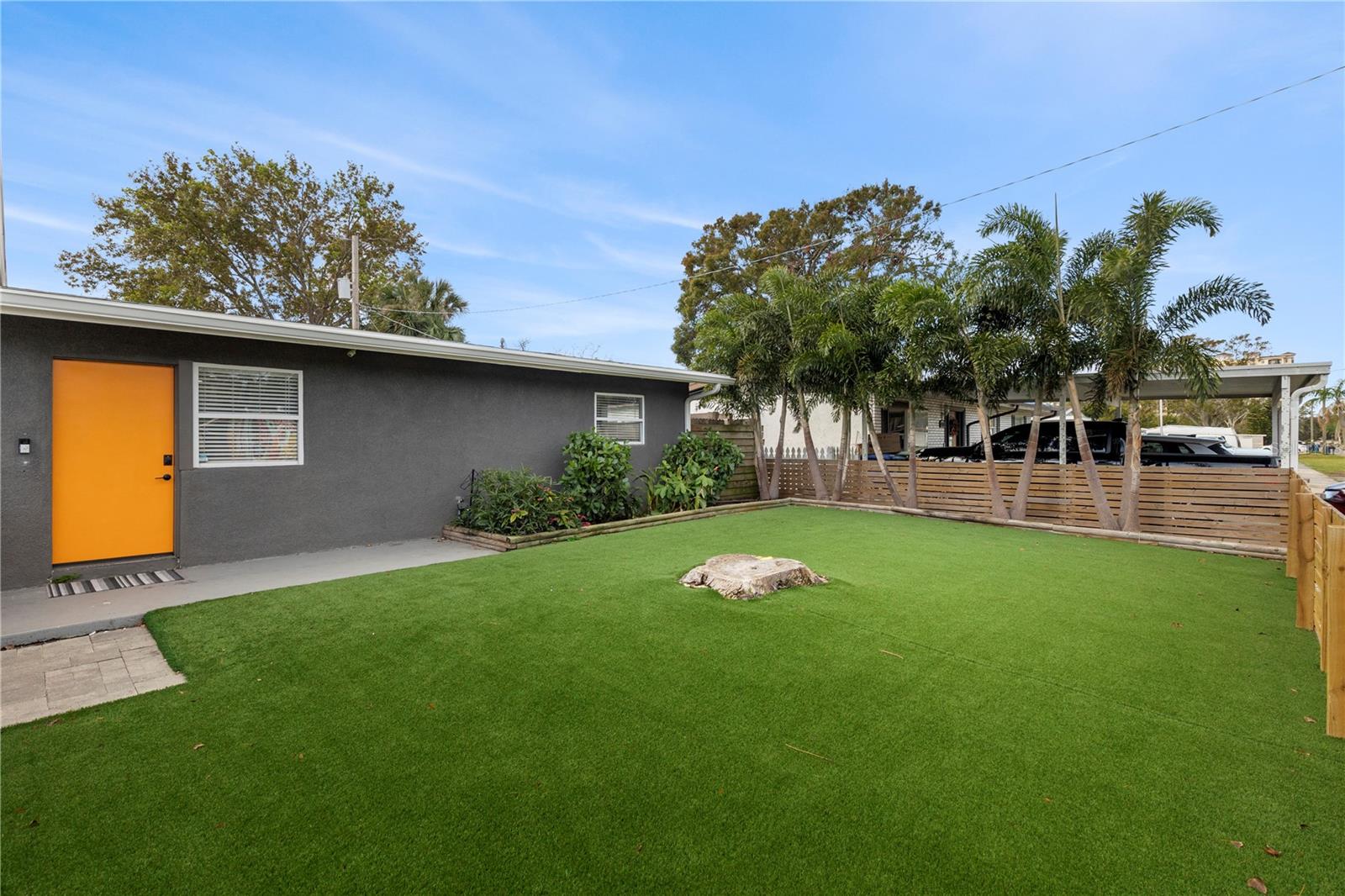 Relax and entertain in the private backyard with low-maintenance artificial turf, a spacious patio area, and lush landscaping, ideal for outdoor gatherings year-round.