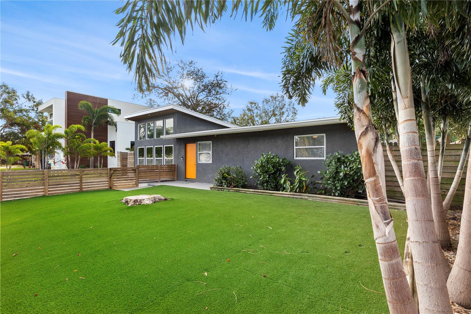 Relax and entertain in the private backyard with low-maintenance artificial turf, a spacious patio area, and lush landscaping, ideal for outdoor gatherings year-round.