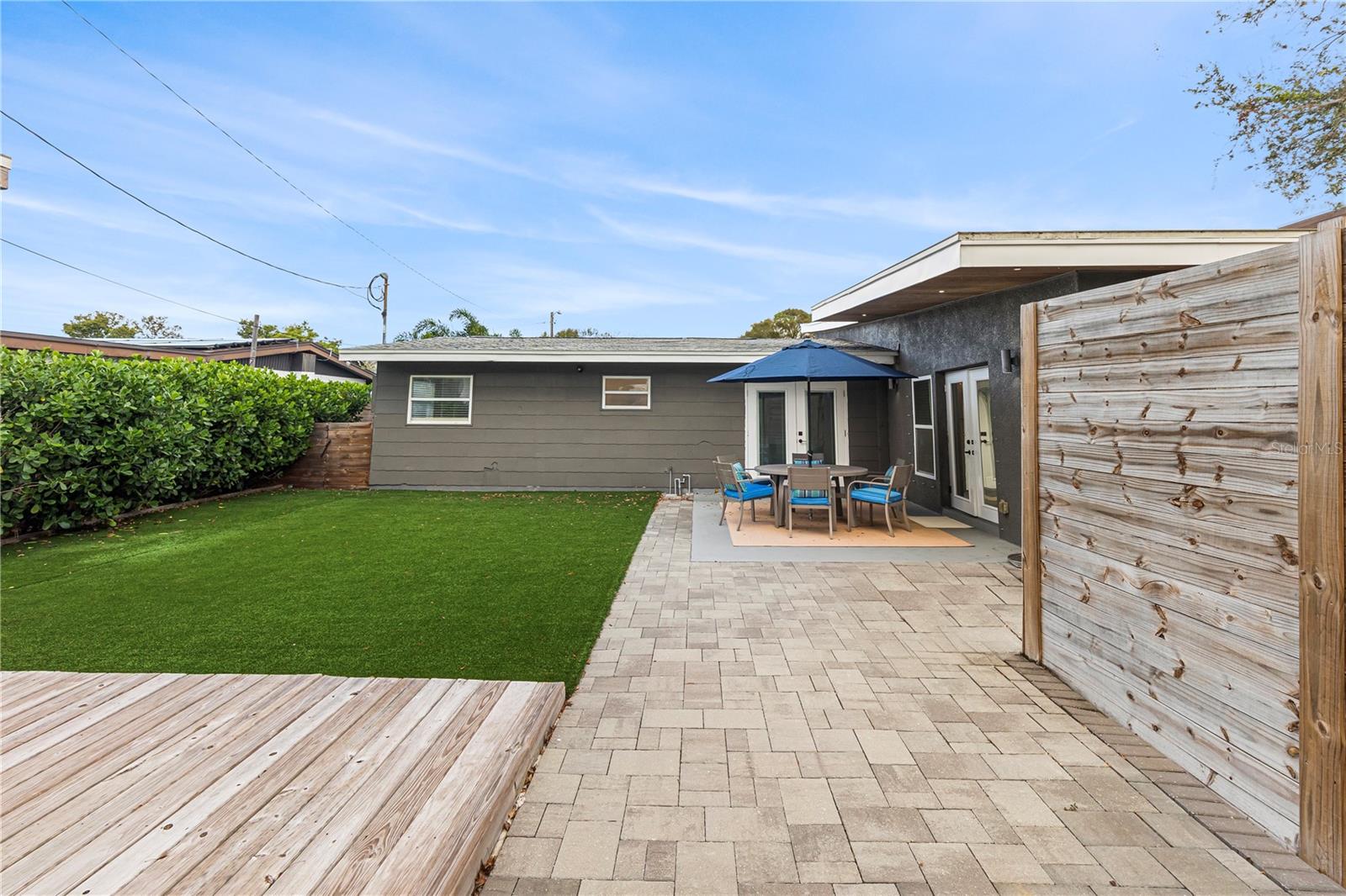 Relax and entertain in the private backyard with low-maintenance artificial turf, a spacious patio area, and lush landscaping, ideal for outdoor gatherings year-round.