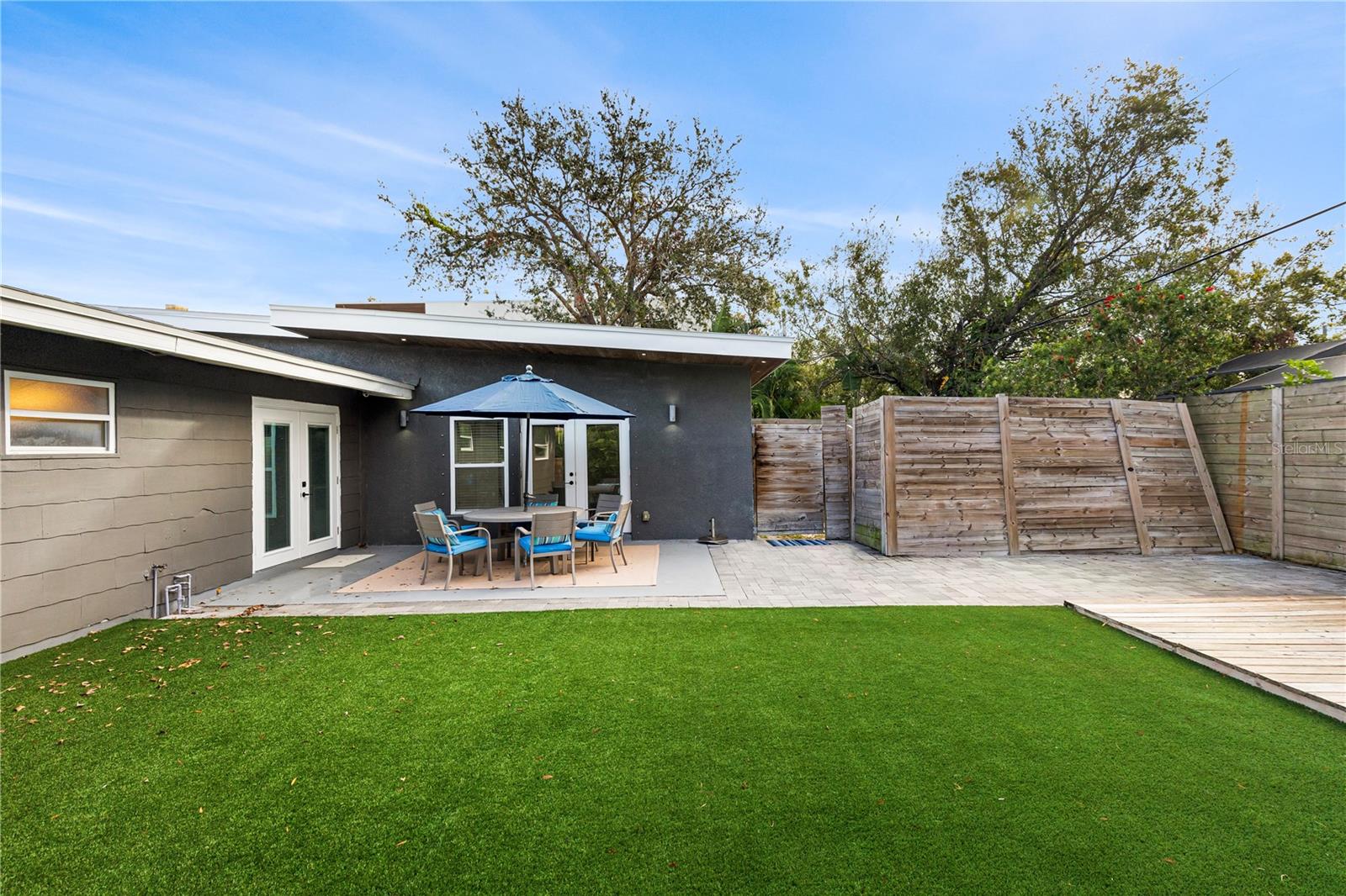 Relax and entertain in the private backyard with low-maintenance artificial turf, a spacious patio area, and lush landscaping, ideal for outdoor gatherings year-round.