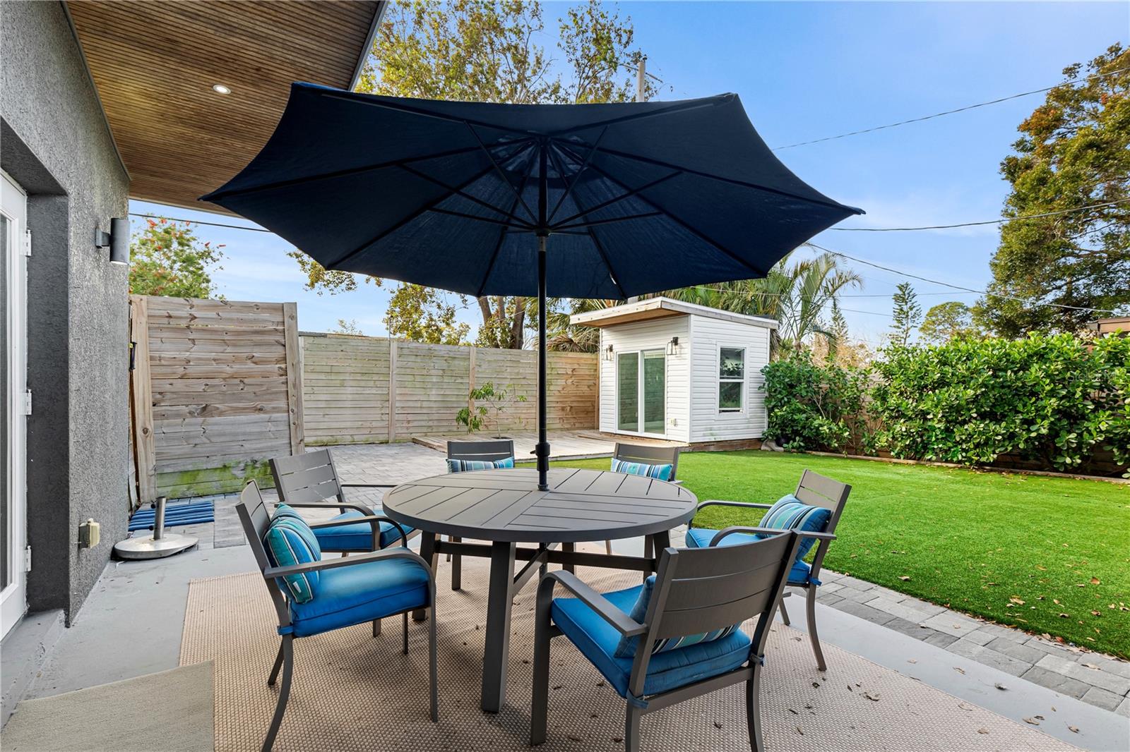 Relax and entertain in the private backyard with low-maintenance artificial turf, a spacious patio area, and lush landscaping, ideal for outdoor gatherings year-round.