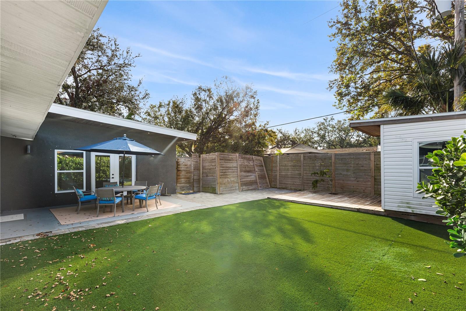 Relax and entertain in the private backyard with low-maintenance artificial turf, a spacious patio area, and lush landscaping, ideal for outdoor gatherings year-round.