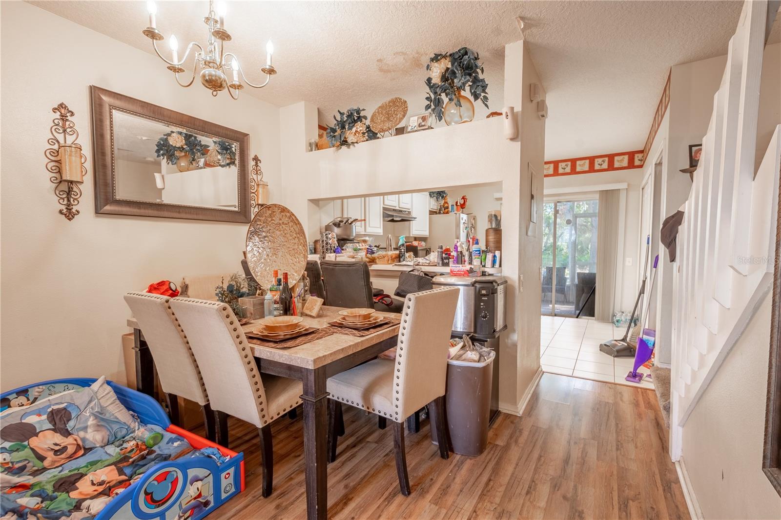 Dining room features wood laminate flooring, a 6 light chandelier and a convenient pass thru to the kitchen.