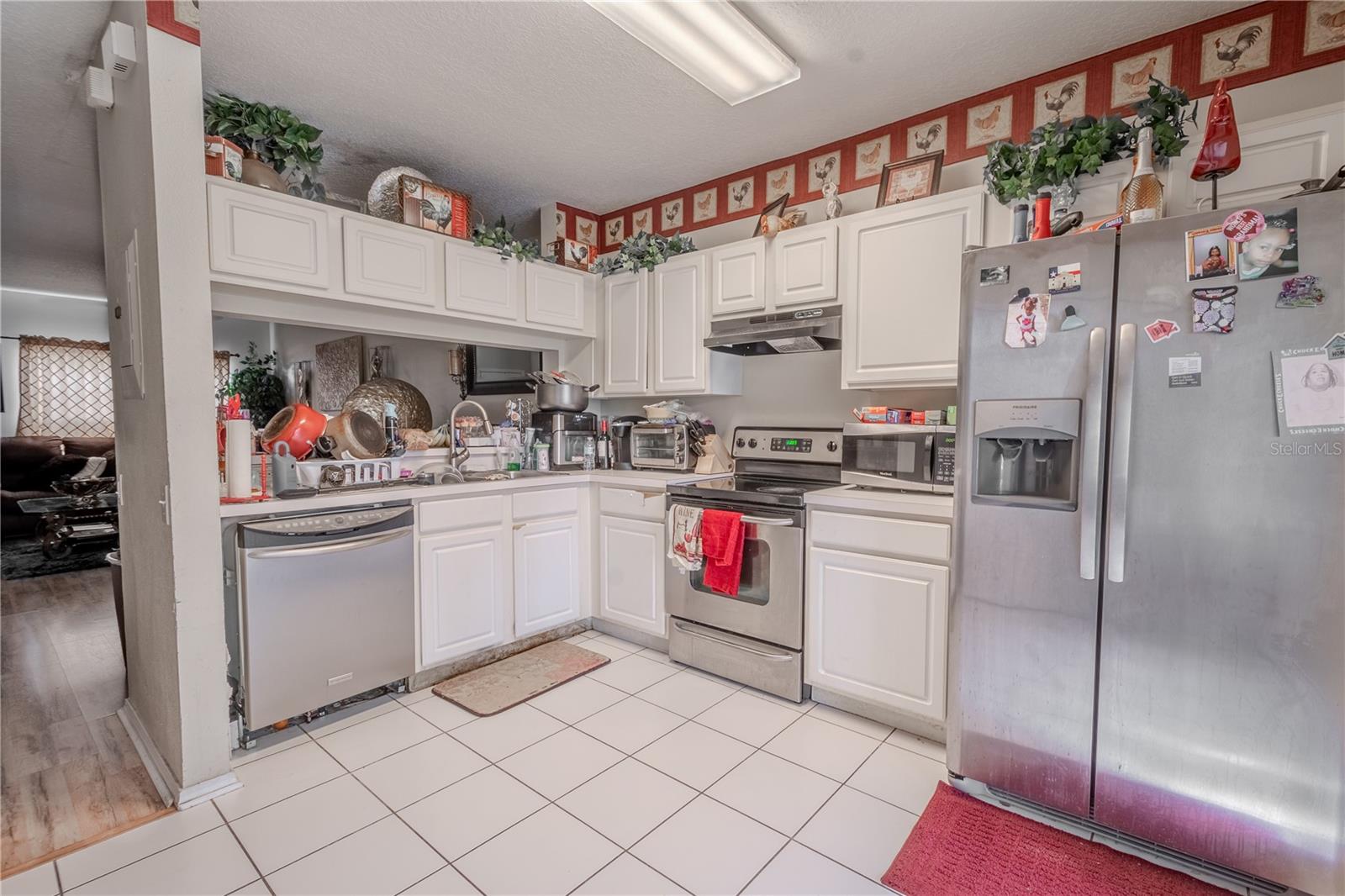 The kitchen features neutral tone cabinets and countertops, and a stainless steel dishwasher. There is a laundry closet with washer/dryer.