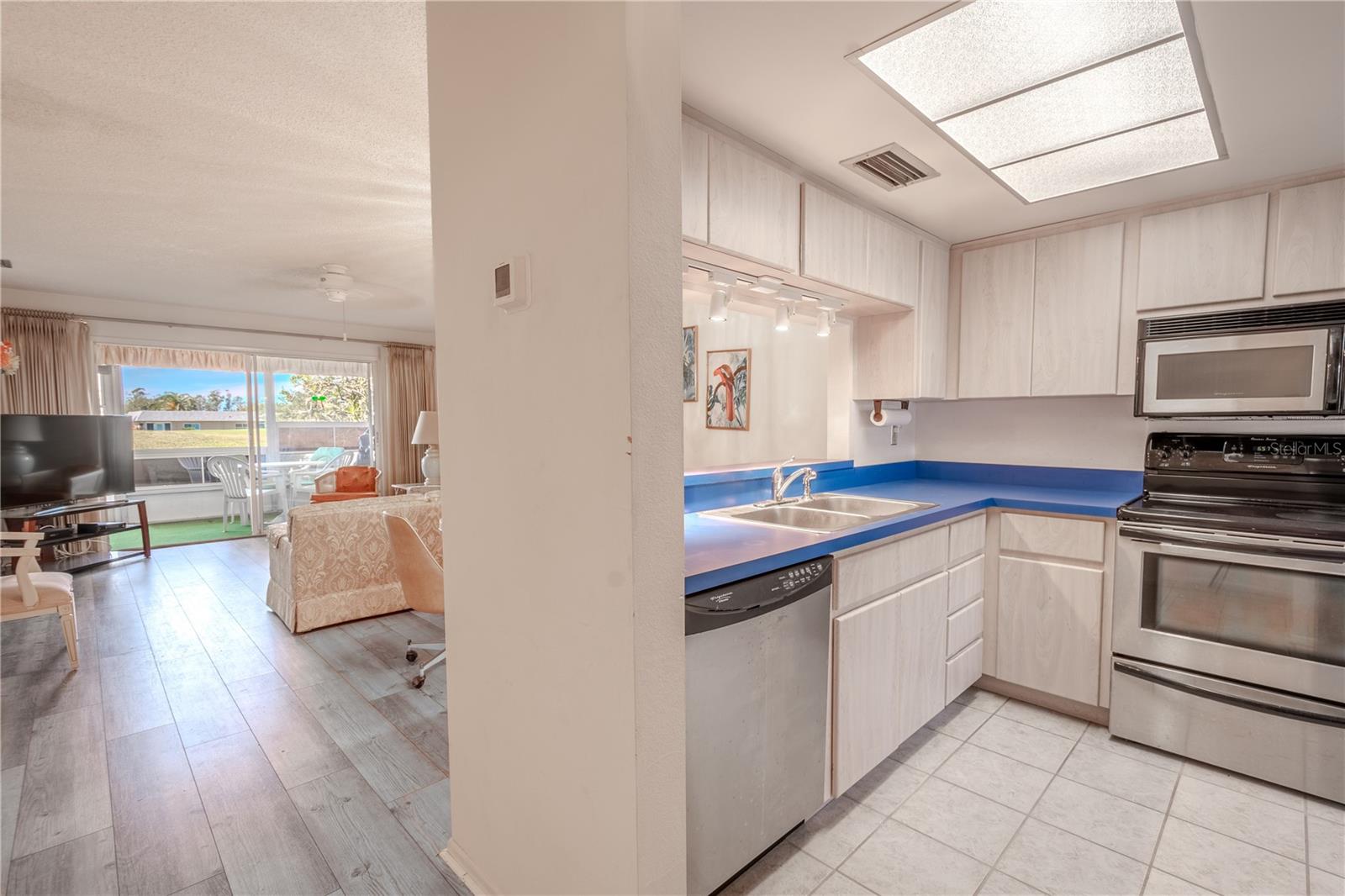 The living and dining areas feature neutral tone wood laminate flooring.