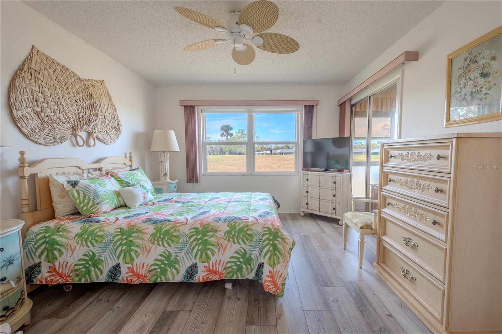 The primary bedroom has sliding glass doors to the screened in lanai.