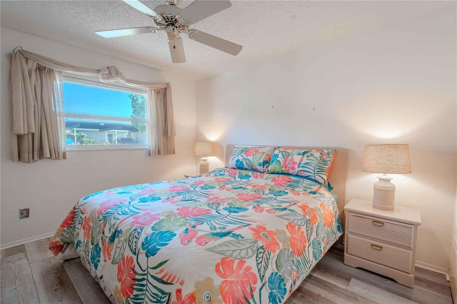 The 2nd bedroom features wood laminate flooring, a ceiling fan and dual built in closets.